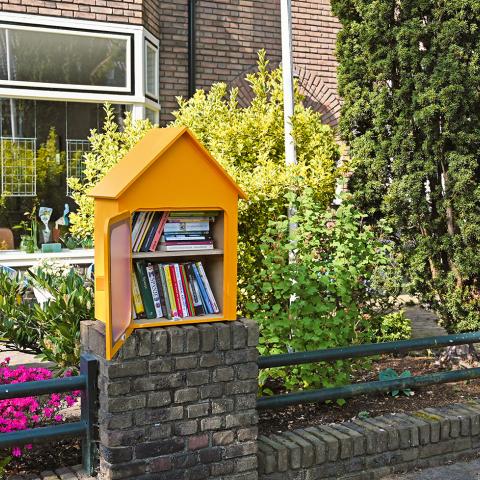 gele minibieb gevuld met boeken op straat