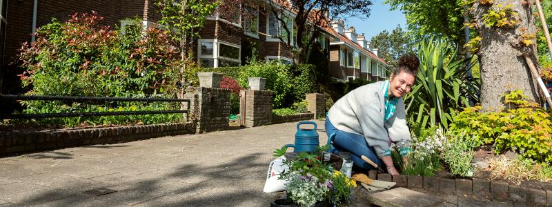 vrouw plant bloemen rondom boom