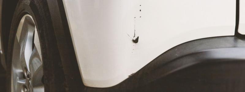 Lakschade op witte auto